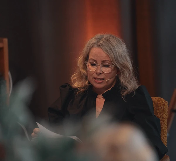 Forfatter Gunnhild Øyehaug sitter på en scene og leser. Nærbilde. Foto.